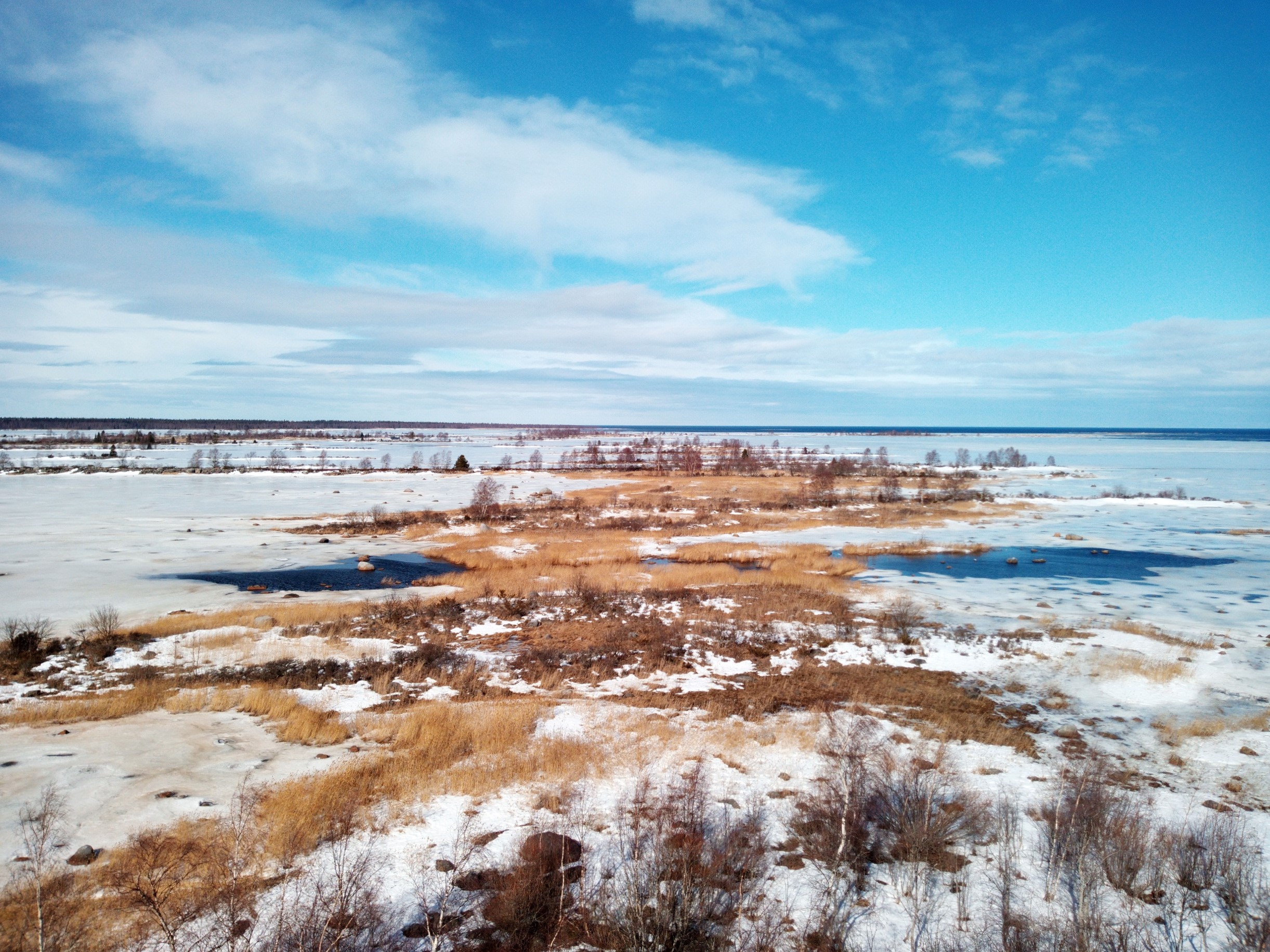 Talvinen maisema Svedjehamnista Merenkurkun saaristosta, jossa meri on jäässä ja kapeita ja pitkiä saaria peittää lumi.